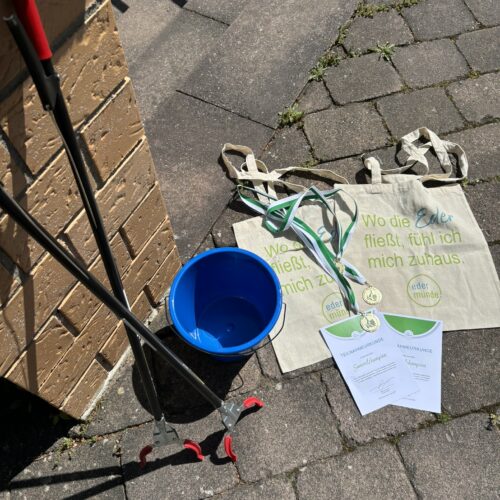 Utensilien zum Müllsammeln, Urkunde, Medaille und Stoffbeutel