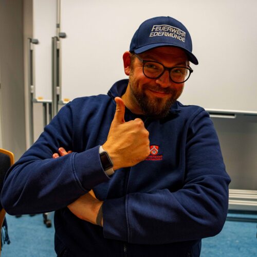 Person in Feuerwehrklamotten hält Daumen hoch